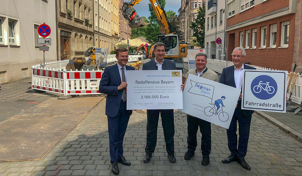 Der Oberbürgermeister von Nürnberg, Marcus König, Ministerpräsident Dr. Markus Söder, Verkehrsminister Christian Bernreiter und Innenminister Joachim Herrmann vor der Baustelle für die Fahrradstraße in Nürnberg. 